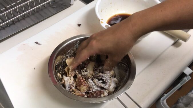 タコに薄力粉を混ぜ合わせる写真